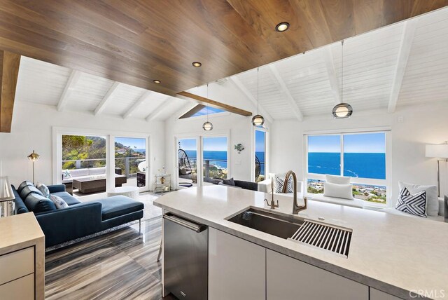 kitchen with sink, hanging light fixtures, lofted ceiling with beams, a water view, and stainless steel dishwasher