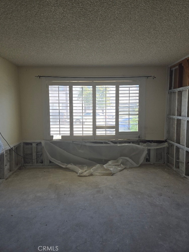 empty room featuring a textured ceiling and a wealth of natural light