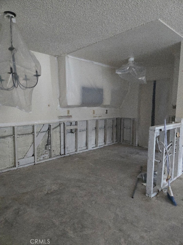 miscellaneous room with carpet floors, a textured ceiling, and lofted ceiling