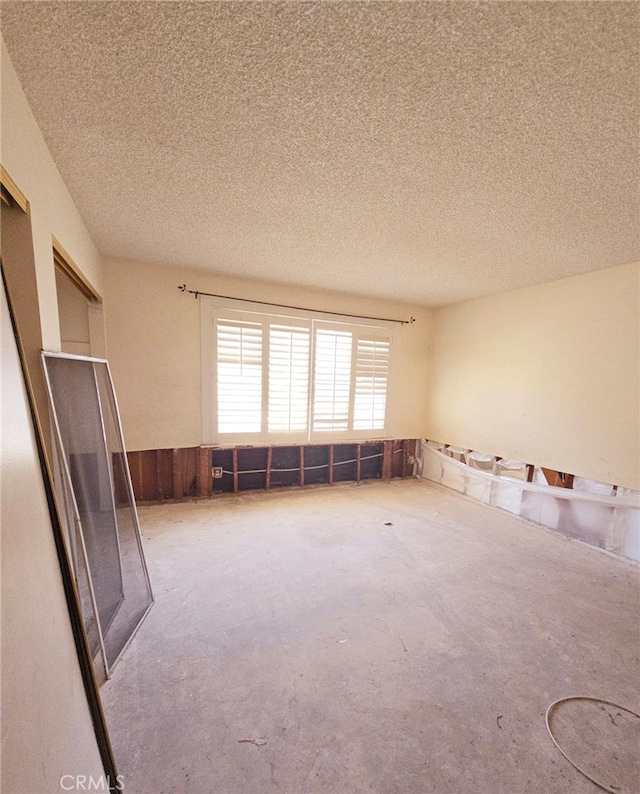 empty room with a textured ceiling and carpet