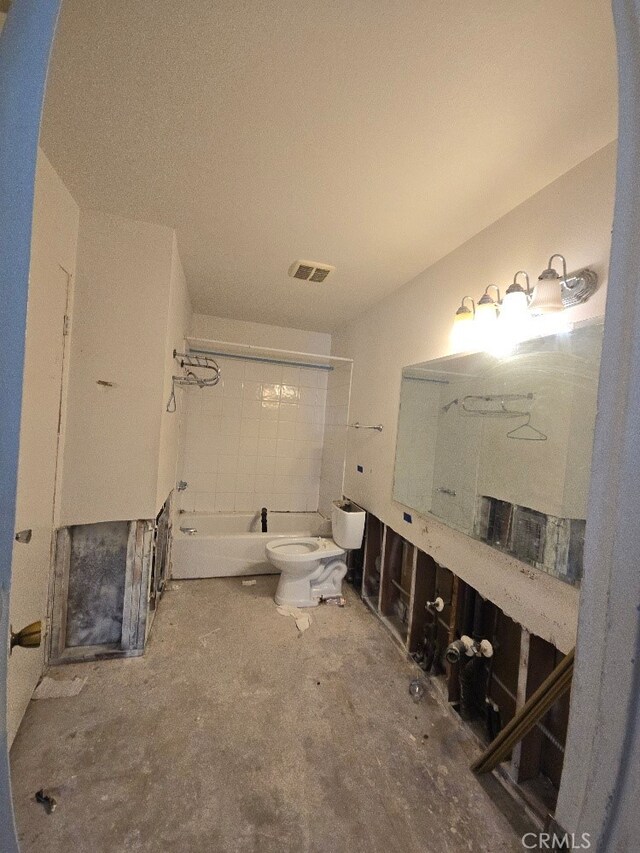 bathroom with toilet, concrete floors, and shower / bathtub combination