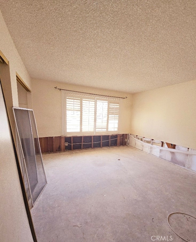 empty room featuring a textured ceiling and carpet