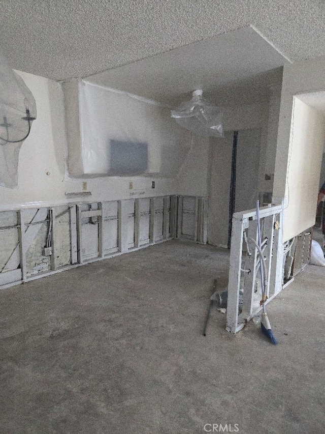 miscellaneous room featuring a textured ceiling and carpet flooring