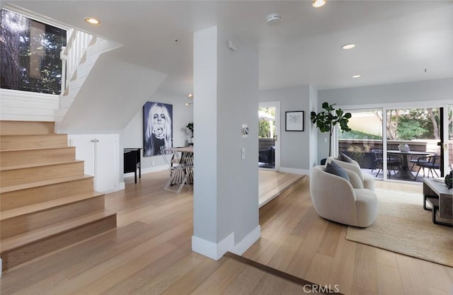 living room featuring light wood-type flooring and a healthy amount of sunlight