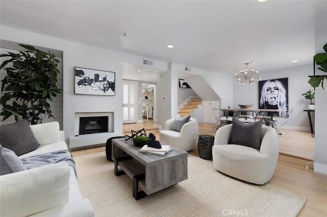 living room featuring a notable chandelier and light wood-type flooring