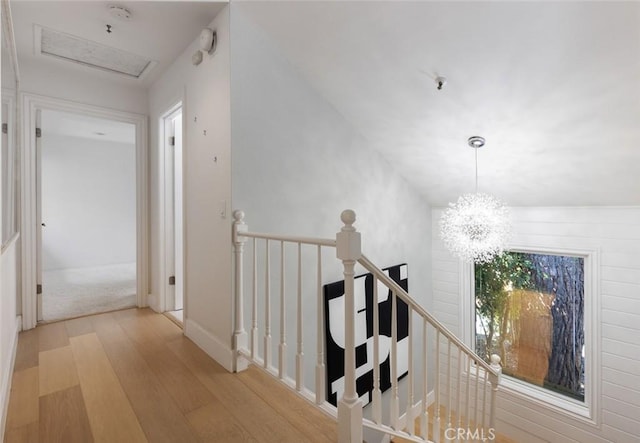 hallway featuring a chandelier and light hardwood / wood-style flooring