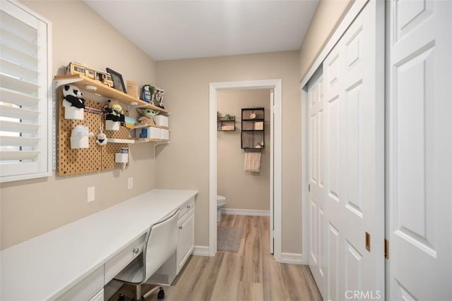 interior space with built in desk and light hardwood / wood-style flooring