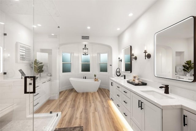 bathroom featuring vanity, hardwood / wood-style flooring, and shower with separate bathtub