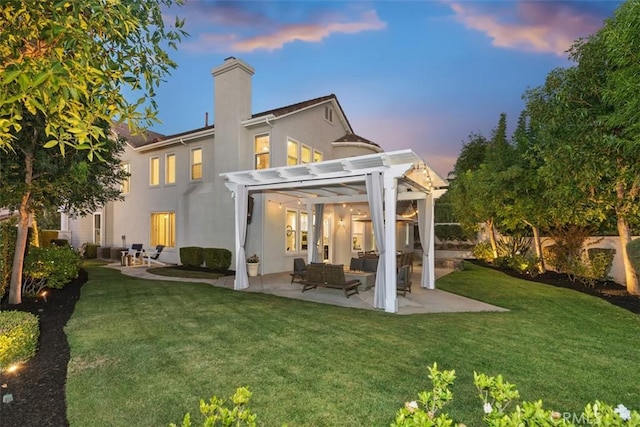 back house at dusk featuring a yard, a pergola, an outdoor hangout area, and a patio area