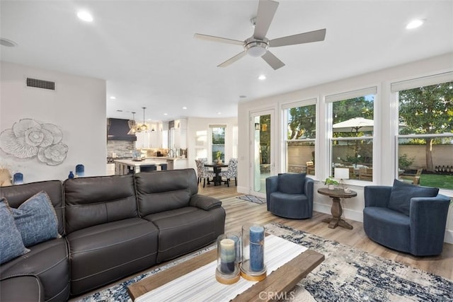 living room with light hardwood / wood-style flooring and ceiling fan