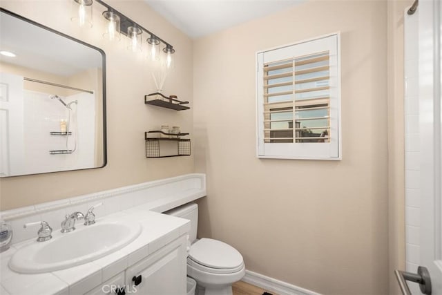 bathroom with vanity, a shower, and toilet