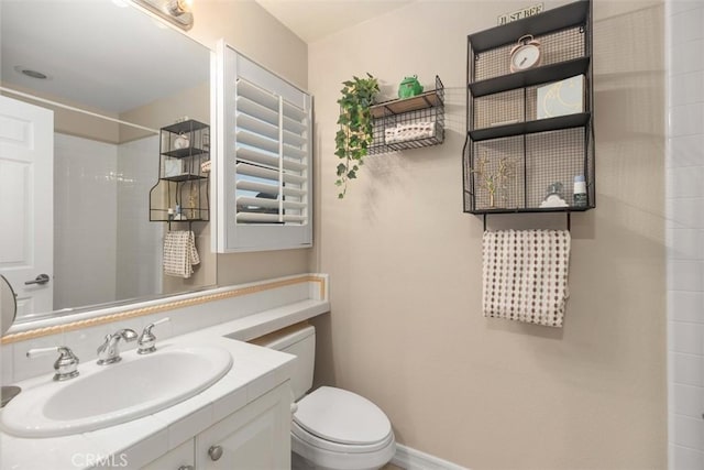 bathroom with vanity, a shower, and toilet