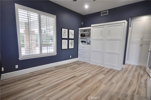 unfurnished bedroom featuring a closet and light wood-type flooring