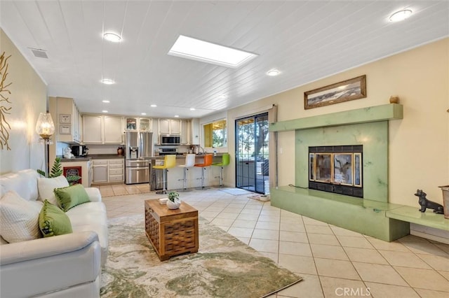 living room with light tile patterned floors and a fireplace