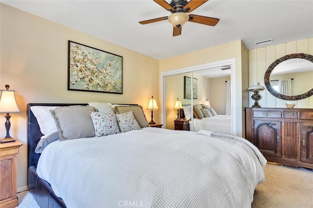 carpeted bedroom with ceiling fan and a closet