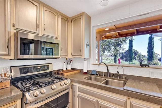 kitchen featuring stainless steel appliances, light brown cabinets, and sink