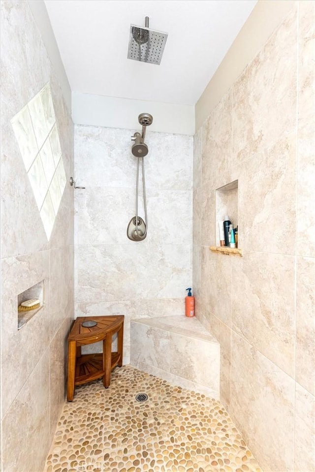 bathroom with tile walls and tiled shower