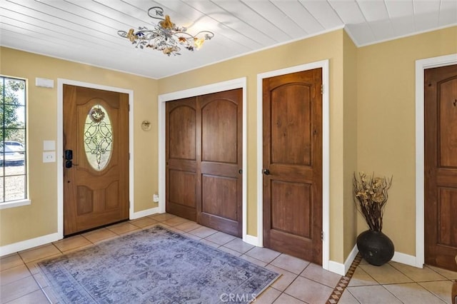 tiled foyer featuring an inviting chandelier