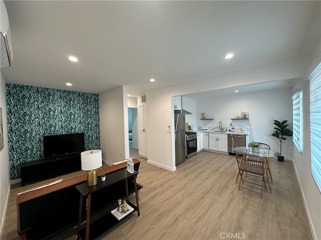 kitchen with white cabinetry, light hardwood / wood-style floors, and appliances with stainless steel finishes