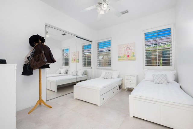 bedroom featuring a closet, ceiling fan, and light tile patterned floors