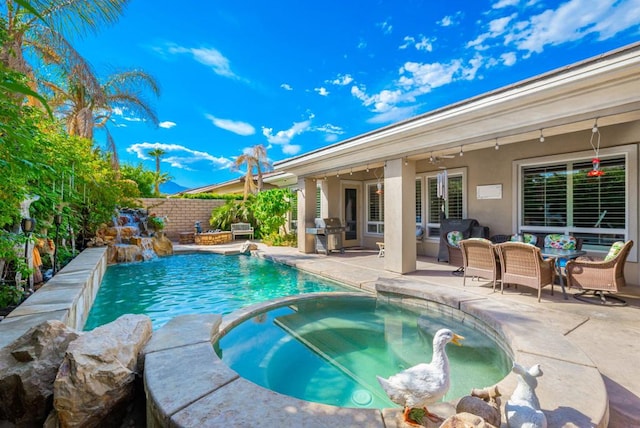 view of pool featuring an in ground hot tub, a patio area, a grill, ceiling fan, and pool water feature