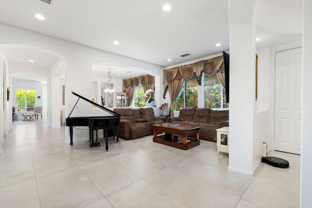 living room featuring a wealth of natural light, a notable chandelier, and light tile patterned flooring