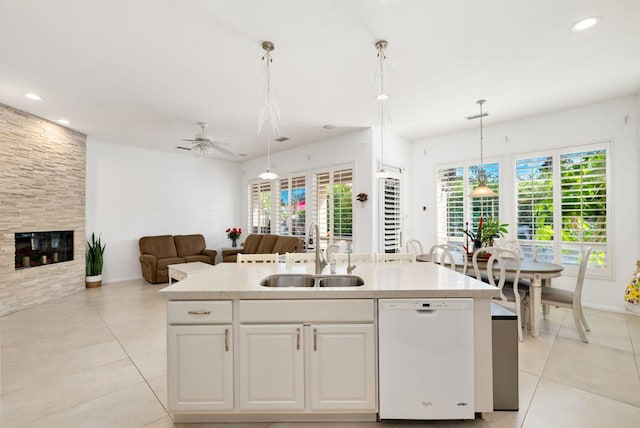 kitchen featuring pendant lighting, white cabinetry, an island with sink, sink, and white dishwasher