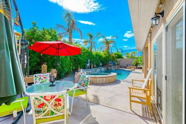 view of patio / terrace with a swimming pool with hot tub