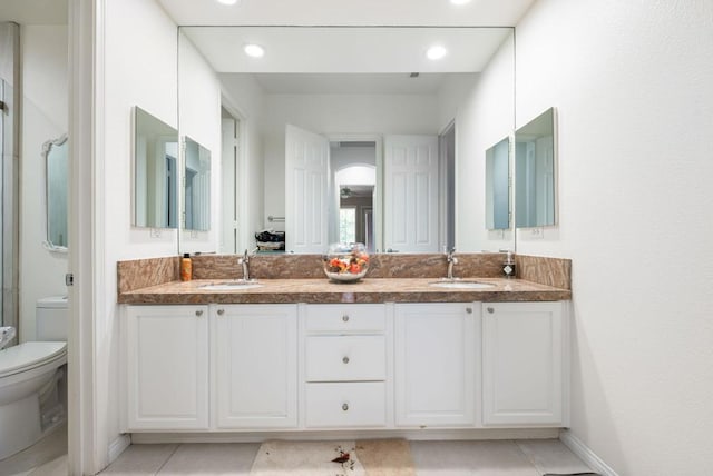 bathroom featuring toilet, tile patterned floors, and vanity