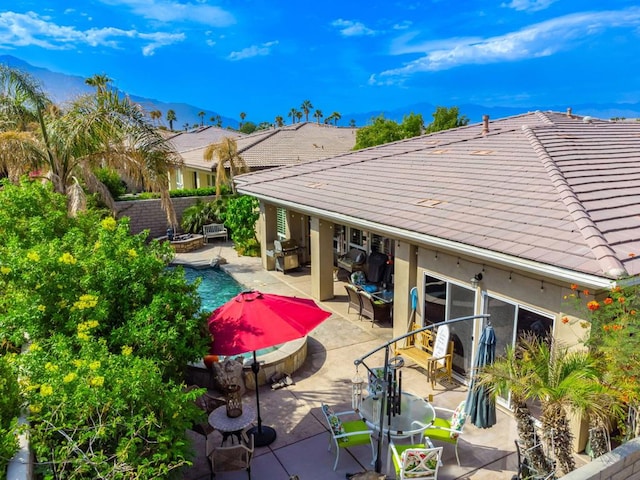 back of house featuring a mountain view and a patio area