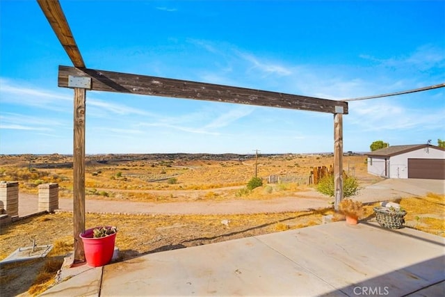 view of yard with an outdoor structure, a garage, and a patio area