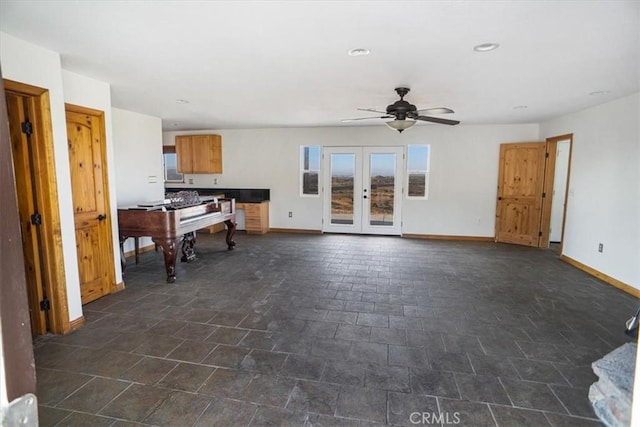 unfurnished living room with ceiling fan and french doors