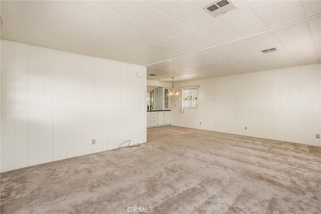 carpeted spare room featuring wooden walls