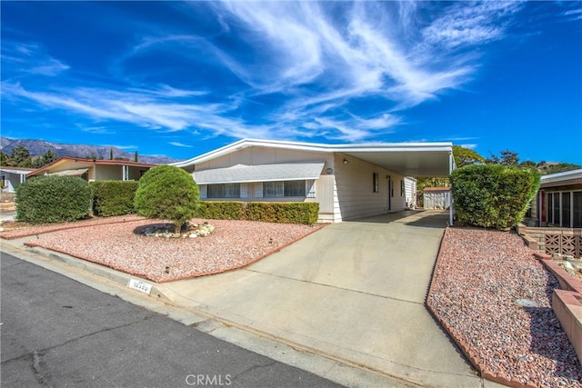 ranch-style home featuring a carport and a mountain view