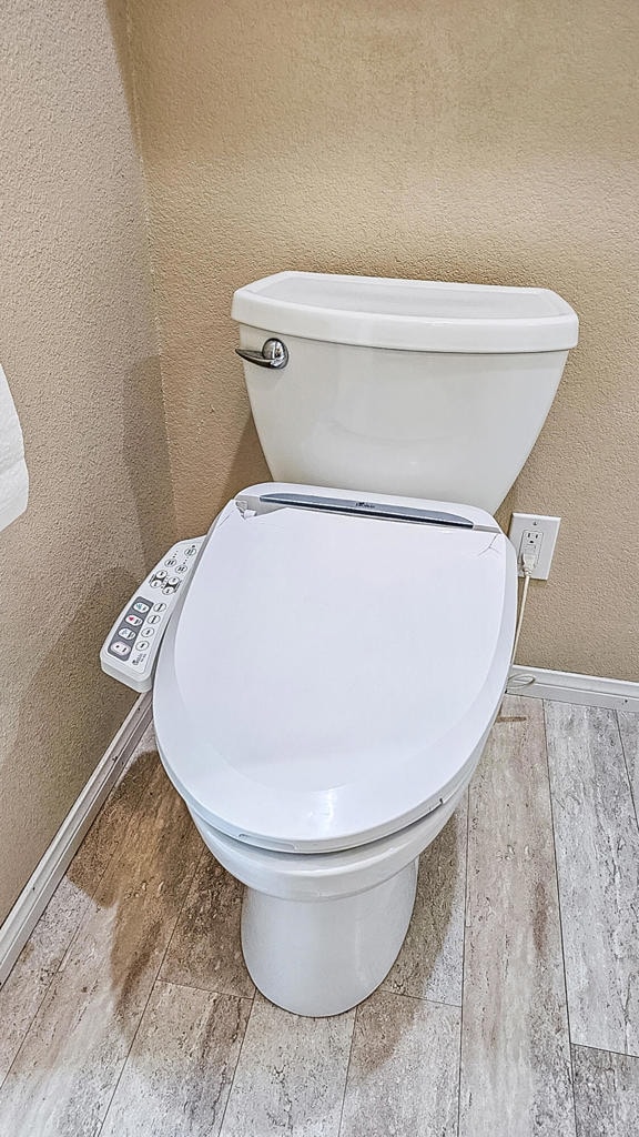 bathroom featuring wood-type flooring and toilet