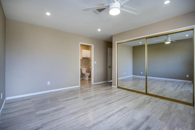 unfurnished bedroom featuring light hardwood / wood-style floors, ceiling fan, ensuite bathroom, and a closet