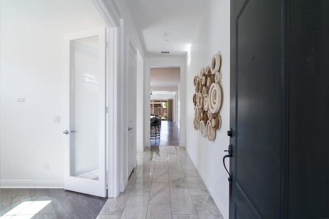 hallway with light hardwood / wood-style floors