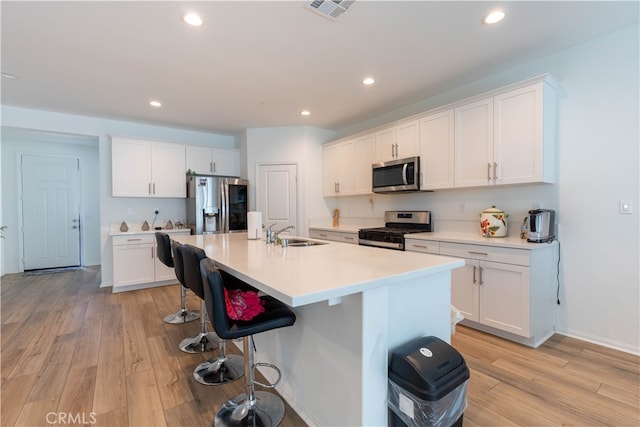 kitchen featuring light hardwood / wood-style floors, stainless steel appliances, and white cabinets