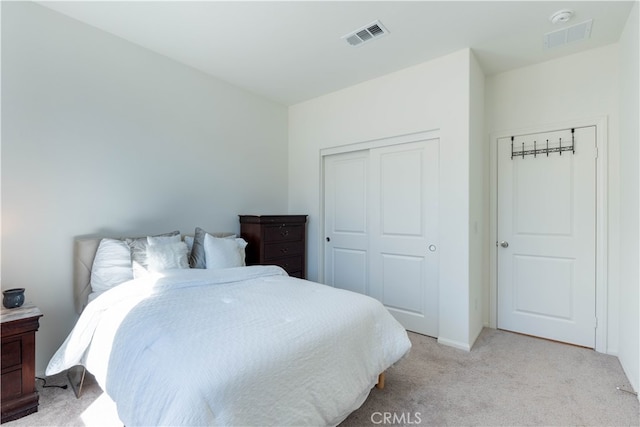 bedroom with light colored carpet and a closet