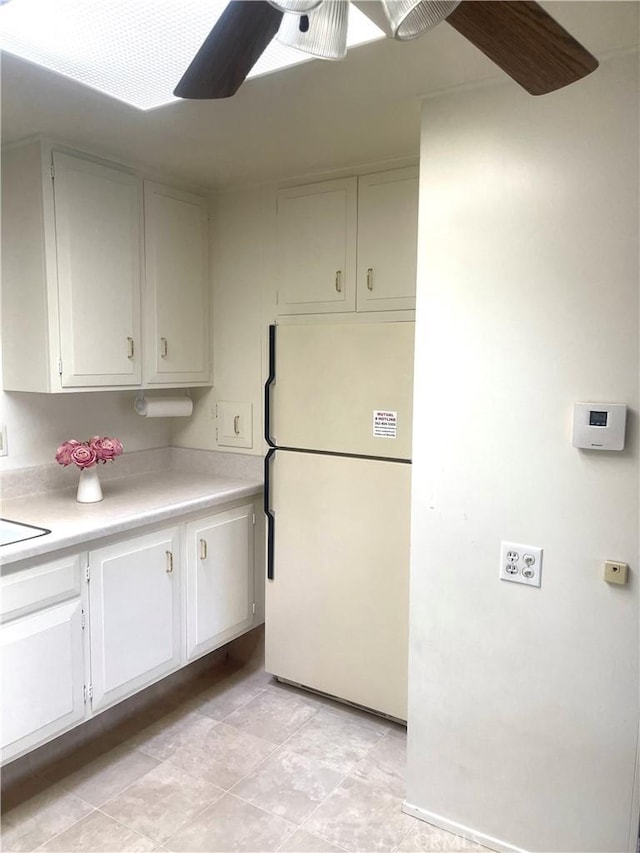 kitchen with white fridge, white cabinetry, and ceiling fan