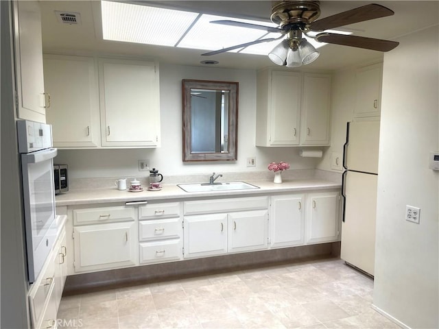 kitchen featuring white cabinetry, sink, ceiling fan, and white appliances