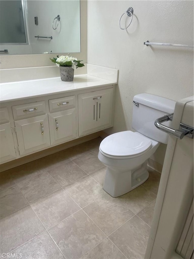 bathroom featuring tile patterned flooring, vanity, and toilet