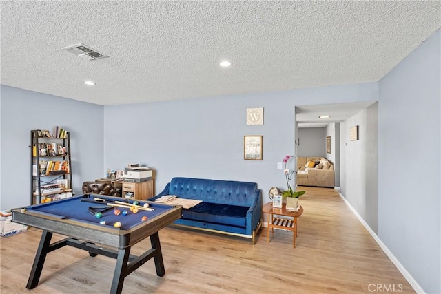 game room featuring pool table, a textured ceiling, and light wood-type flooring