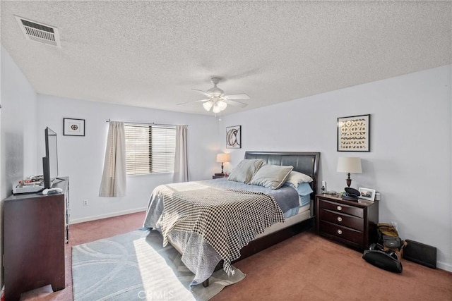 carpeted bedroom featuring a textured ceiling and ceiling fan