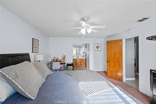 carpeted bedroom featuring a textured ceiling and ceiling fan