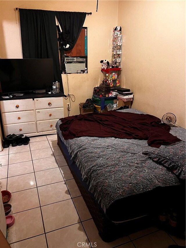 bedroom with cooling unit and light tile patterned floors