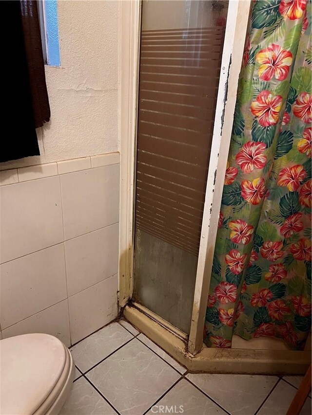 bathroom featuring tile patterned floors, walk in shower, and toilet