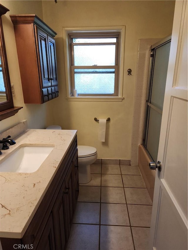 full bathroom with tile patterned floors, vanity, enclosed tub / shower combo, and toilet