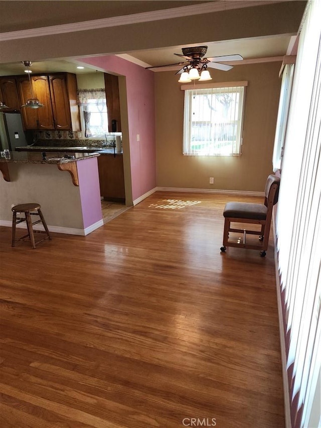 kitchen featuring ornamental molding, dark hardwood / wood-style flooring, and a breakfast bar area