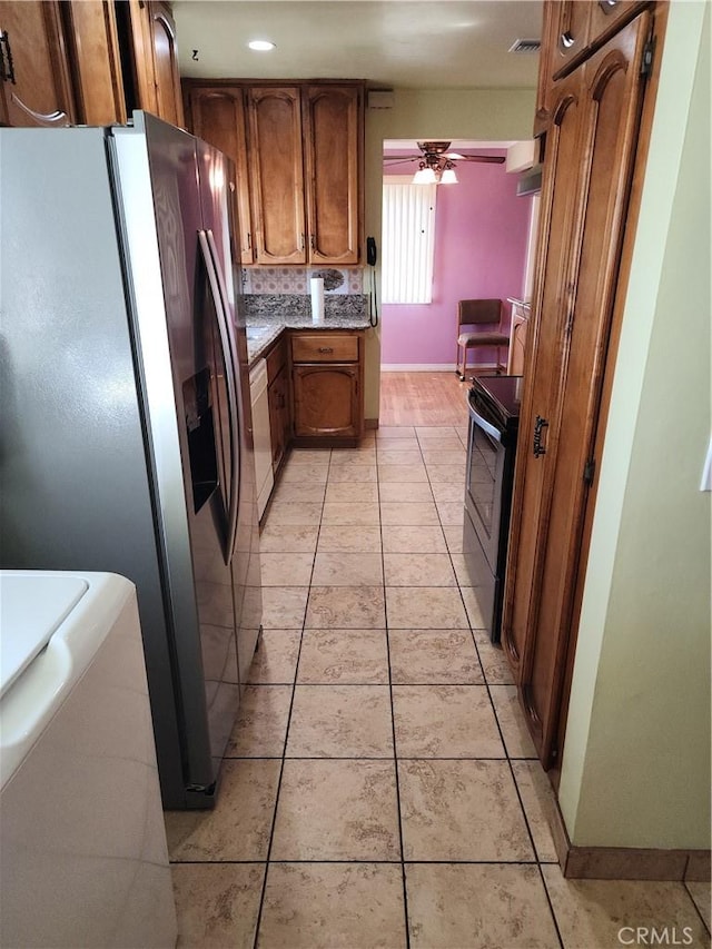 kitchen featuring ceiling fan, dishwasher, stainless steel fridge with ice dispenser, black / electric stove, and light tile patterned flooring